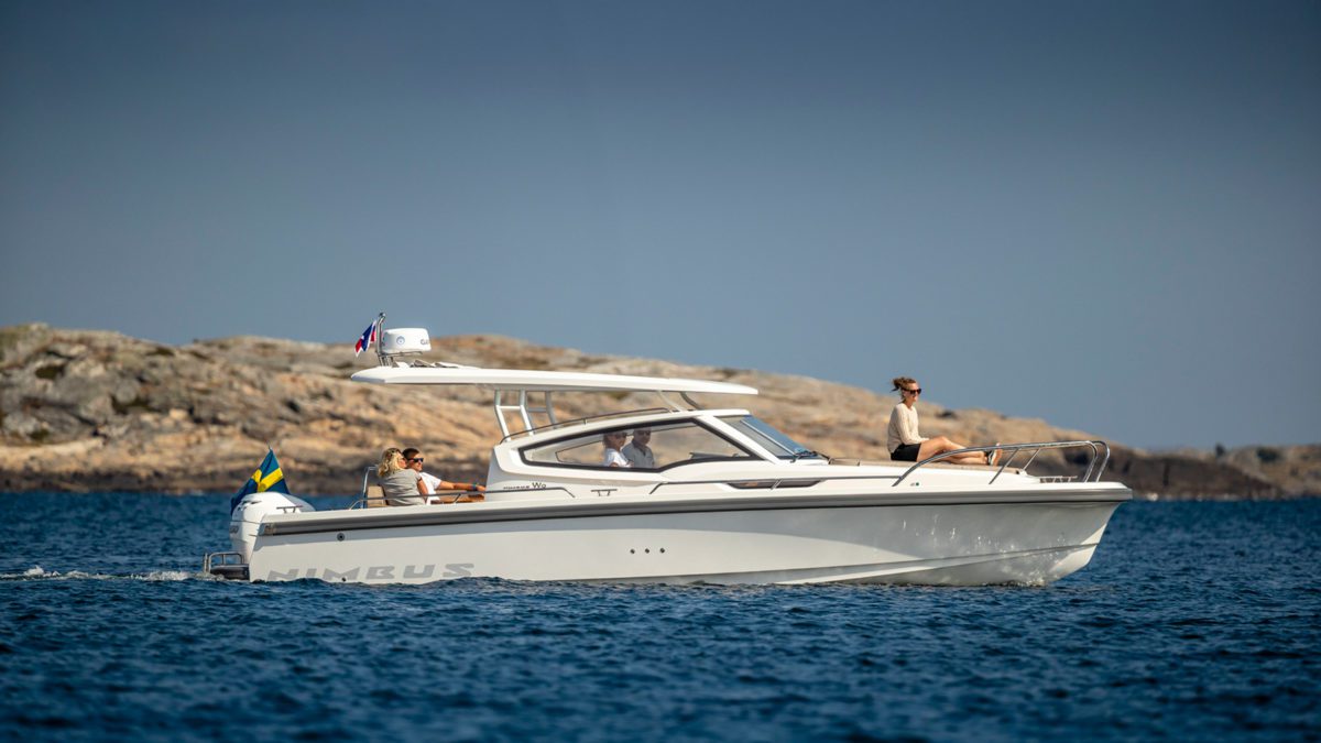 Nimbus boat driving in the sun next to a cliff