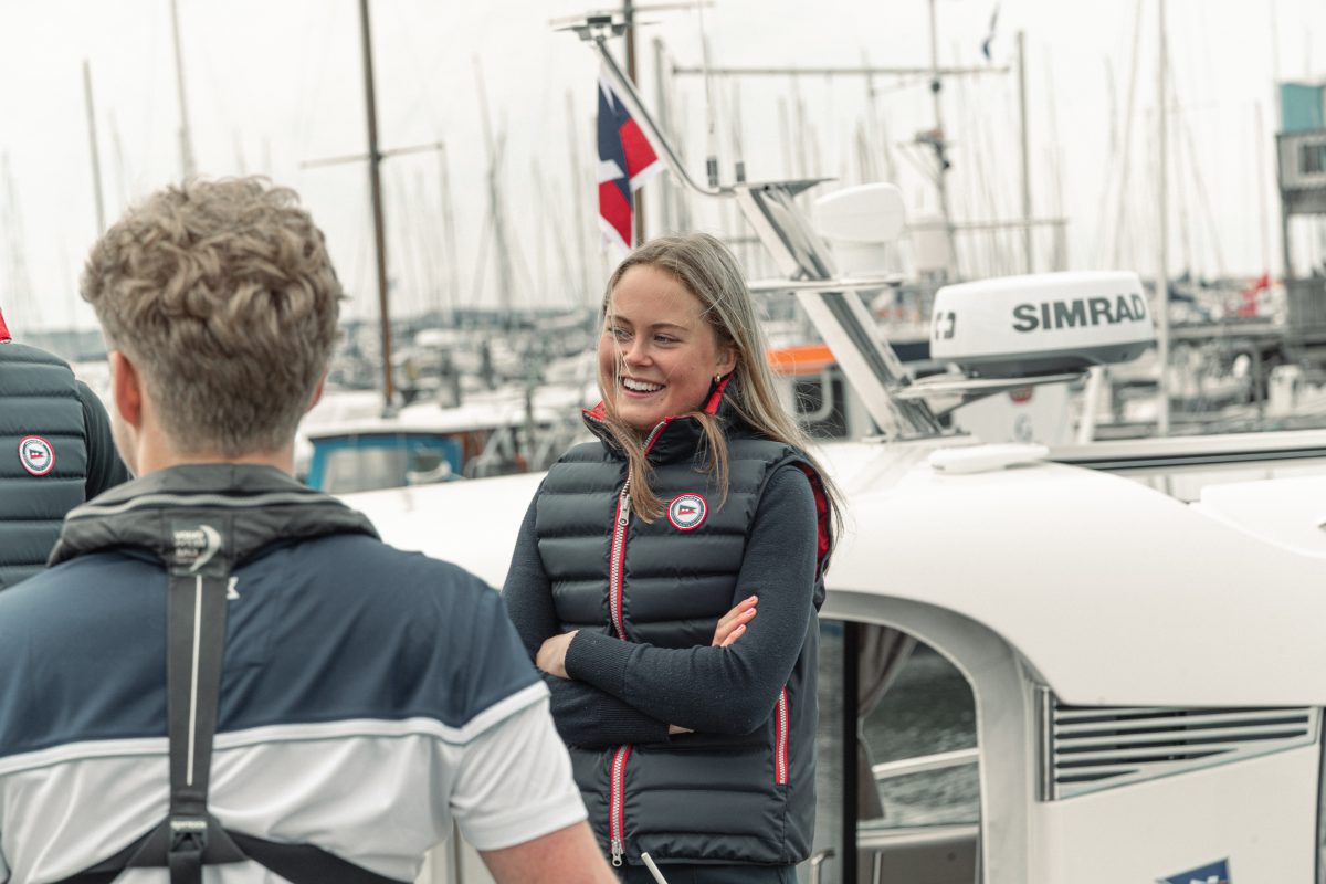 Girl smiling in the harbour with a back vest on